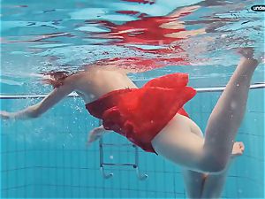 crimson clothed nubile swimming with her eyes opened